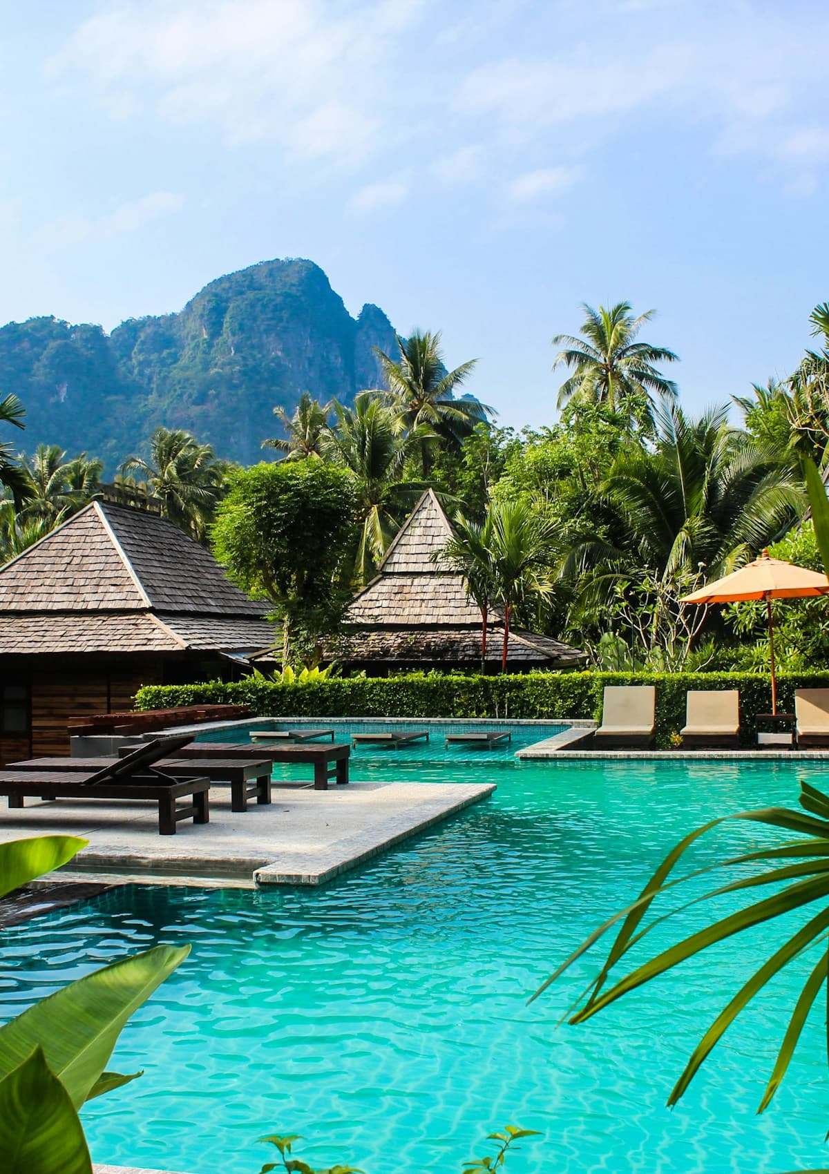 Poolside villas surrounded by tropical palms and mountains